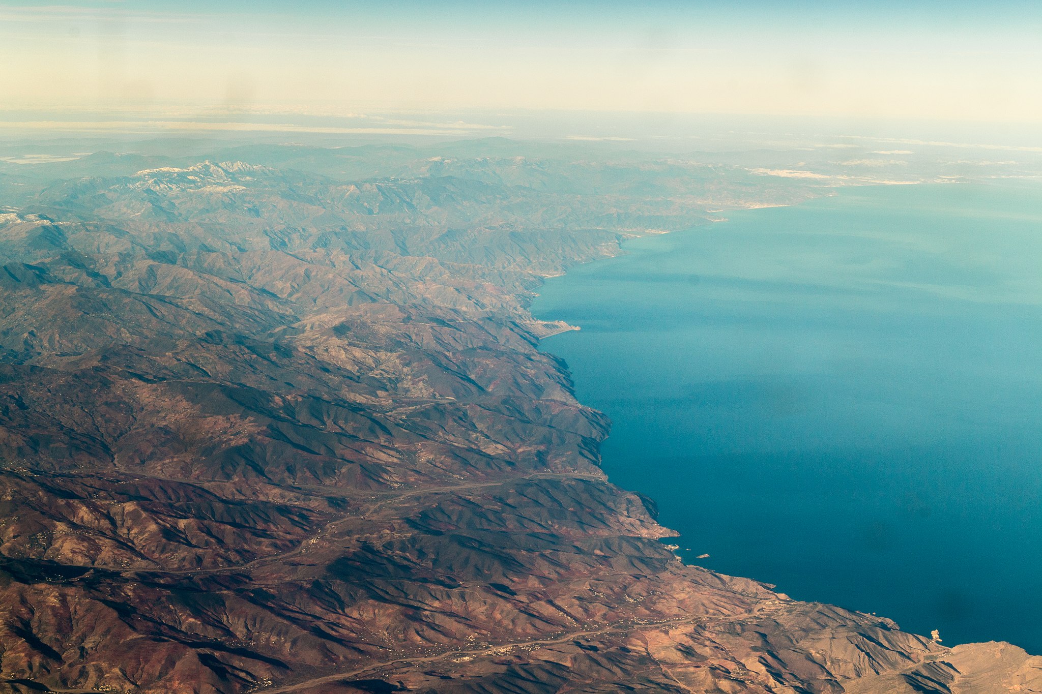 Aerial photograph of the Mediterranean coast of northern Morocco, with mountains running down to the sea.