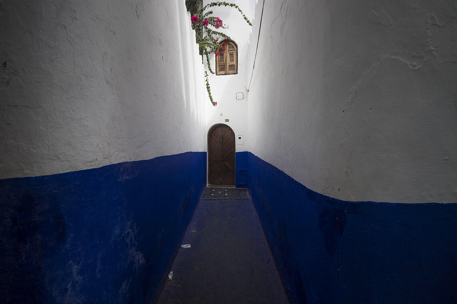 A quiet blue-painted alley in Chefchaouen, in the western Rif of northern Morocco, with no people in frame.