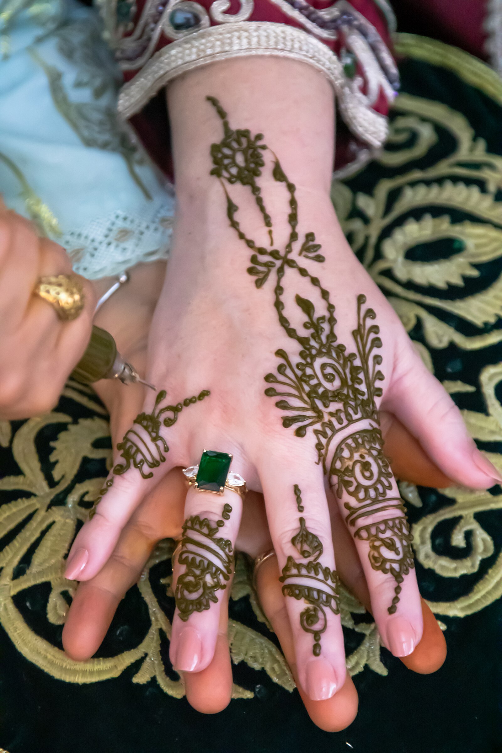 Detailed henna designs on a bride's hands, applied during a Moroccan wedding henna night.