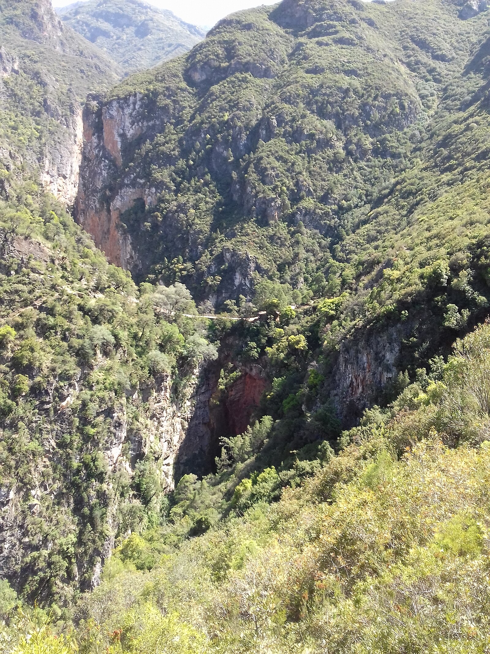 Akchour valley in the Rif mountains of northern Morocco, with green slopes and a stone village in the foreground.