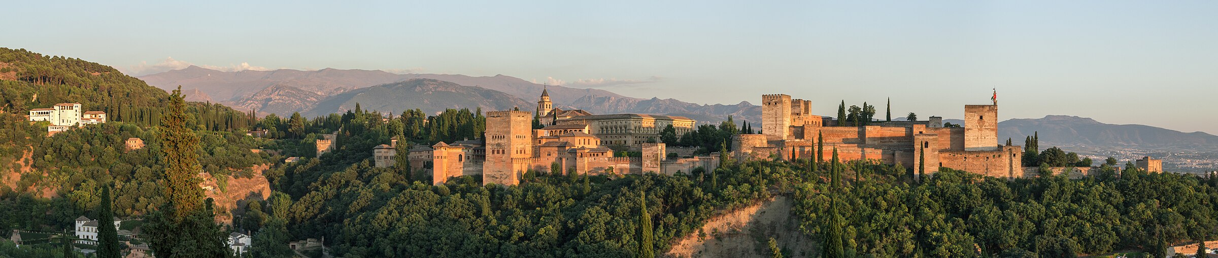 Evening panorama of the Alhambra palace in Granada, photographed from the Mirador San Nicolas with the Sierra Nevada behind.
