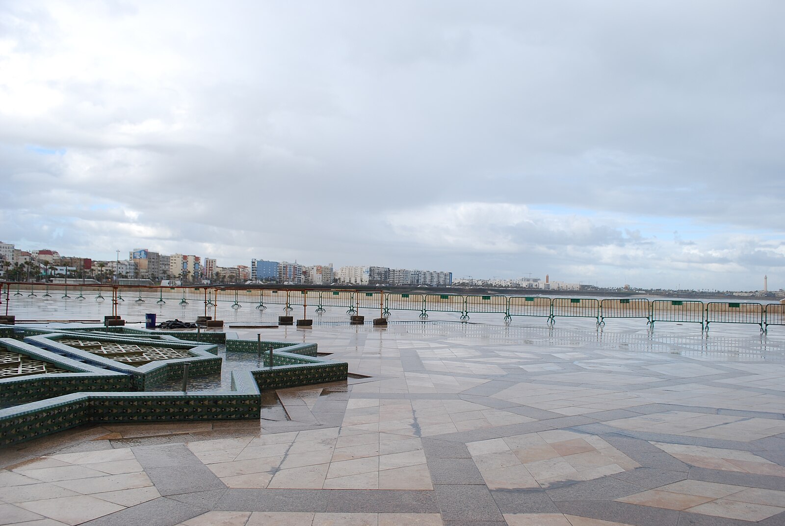 The plaza in front of the Hassan II Mosque in Casablanca, with the minaret visible and the Atlantic behind.