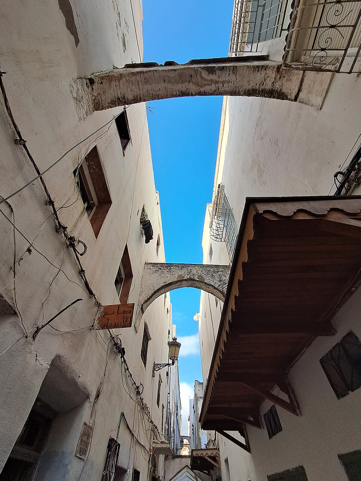 A whitewashed alley in the medina of Tetouan in northern Morocco, with arched doorways and tiled accents.